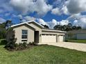 Single-story home with a three-car garage, manicured lawn, and tasteful landscaping, offering great curb appeal at 9049 Players Dr, Weeki Wachee, FL 34613