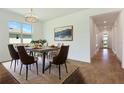 Bright dining room featuring modern chandelier, stylish furniture and decorative wall art at 9071 Players Dr, Weeki Wachee, FL 34613