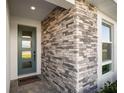 Inviting front porch with stone accents and a stylish front door with glass panels at 9071 Players Dr, Weeki Wachee, FL 34613