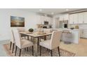 Bright dining area with a table set for six, with the kitchen and white cabinetry in the background at 9093 Players Dr, Weeki Wachee, FL 34613