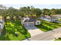 Expansive aerial view of the home showcasing its lush green lawn and neighborhood at 9109 Players Dr, Weeki Wachee, FL 34613