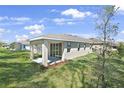 Backyard view with covered patio and lush lawn, perfect for outdoor entertaining at 9109 Players Dr, Weeki Wachee, FL 34613