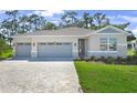 Charming single-Gathering home features a three-car garage, stone accents, and well-manicured lawn at 9109 Players Dr, Weeki Wachee, FL 34613
