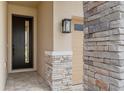 Close-up of the front door and stone accent wall by the attached two car garage entrance at 9157 Players Dr, Weeki Wachee, FL 34613