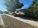 Charming single story home featuring desert landscaping, a large tree, and stone accents at 7403 Foxbloom Dr, Port Richey, FL 34668
