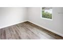 Cozy bedroom featuring wood-look flooring and a bright window offering natural light at 104 Australian Dr, Rotonda West, FL 33947