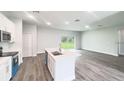 Bright, open kitchen features a central island and stainless steel appliances, flowing into the living area at 104 Australian Dr, Rotonda West, FL 33947