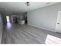 Open-concept living room with wood floors and stainless steel kitchen appliances at 104 Australian Dr, Rotonda West, FL 33947