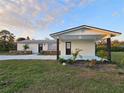 Welcoming single-story home featuring fresh white paint, black accents, and green yard at 460 Creek Lane Dr, Englewood, FL 34223