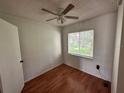 Bedroom featuring wood floors, a window with blinds and a ceiling fan with lights at 7522 Needle Leaf Pl # 27, Tampa, FL 33617