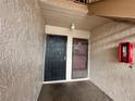 Condo entrance featuring dual doors, textured walls and a red fire extinguisher at 7522 Needle Leaf Pl # 27, Tampa, FL 33617