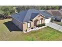 Single-story house with neutral paint, manicured front yard, and attached two-car garage at 6416 Melacano Ave, Spring Hill, FL 34608