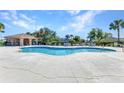 Large community pool featuring a covered lounge area, ample seating, and beautiful landscaping at 2640 Suncoast Lakes Blvd, Punta Gorda, FL 33980