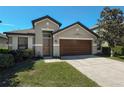 Charming home with a well-maintained lawn, a two-car garage, and mature landscaping at 675 Hartford Heights St, Spring Hill, FL 34609