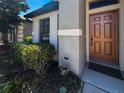 Close-up of front door showing lovely landscaping, a decorative welcome sign, and a dark mat at 675 Hartford Heights St, Spring Hill, FL 34609