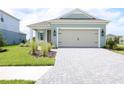 Charming single-Gathering home with a light green exterior, a two-car garage, and manicured landscaping at 14552 Skipping Stone Loop, Parrish, FL 34219
