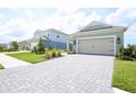 Charming single-Gathering home featuring a two-car garage, a stone driveway, and a well-manicured lawn at 14552 Skipping Stone Loop, Parrish, FL 34219