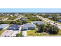 A neighborhood aerial showcases homes with lush greenery and landscaping in a sunny environment at 159 Antilla Dr, Rotonda West, FL 33947