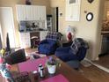 Inviting living area with blue reclining chairs, a desk area, and open to the kitchen at 5840 43Rd N Ter # 1511, St Petersburg, FL 33709