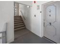Hallway view featuring stairs and a unit entrance door with secure entry at 5501 80Th N St # 201, St Petersburg, FL 33709
