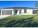 Charming single-story home featuring a gray garage door and freshly cut grass at 2082 Winningway St, Port Charlotte, FL 33948