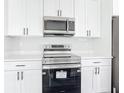 Modern kitchen features stainless steel appliances, white cabinets, and sleek countertops at 21355 Cottonwood Ave, Port Charlotte, FL 33952