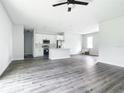 Open-concept living area with modern gray vinyl flooring, a bright white kitchen, and ample natural light at 21355 Cottonwood Ave, Port Charlotte, FL 33952