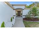 Welcoming front entrance with a stylish dark wood door, stone landscaping, and a freshly painted facade at 2503 Dumont Ln, North Port, FL 34286