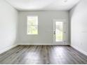 Bright living room with neutral walls and stunning wood-look flooring, enhanced by natural light at 17041 Malta Ave, Port Charlotte, FL 33954