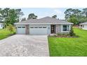 Charming one-story home with a three-car garage, attractive stone details, and a brick-paved driveway at 9143 Players Dr, Weeki Wachee, FL 34613