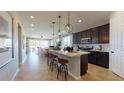 Open-concept kitchen featuring a large center island with pendant lighting and sleek stainless steel appliances at 9176 Players Dr, Weeki Wachee, FL 34613