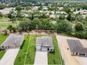 New construction home showing the lot lines on a manicured lawn with a paved driveway and two-car garage at 9177 Players Dr, Weeki Wachee, FL 34613