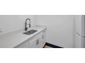 Updated kitchen showcasing white cabinetry, stainless steel sink with black faucet, and subway tile backsplash at 2353 Shelley St # 10, Clearwater, FL 33765