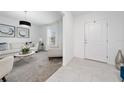Bright living room with tile and carpet flooring, white walls, modern furniture, and a stylish contemporary light fixture at 3884 Capri Coast Dr, Plant City, FL 33565