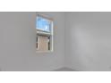 Minimalist bedroom with white walls and window view of the exterior at 488 Sunset N Rd, Rotonda West, FL 33947