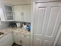 White cabinets, granite countertops, stainless steel appliances, and tile backsplash at 6009 Sea Ranch Dr # 101, Hudson, FL 34667