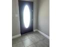 Tile entryway with an oval front door and neutral walls at 15008 Spokane Rd, Spring Hill, FL 34610