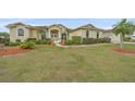 Inviting home featuring a beautifully landscaped front yard, mature trees, and a welcoming entrance at 18011 Prairie Wolf Gln, Parrish, FL 34219