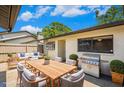 A staged outdoor patio features a grill, dining table, and seating for entertaining at 1961 Whitney Way, Clearwater, FL 33760
