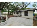Quaint house with a concrete driveway, neutral paint, metal roof and charming yard decor at 2804 Robinson Rd, Plant City, FL 33565