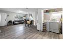 Open-plan living room and laundry area with wood-look floors, neutral walls, and modern appliances at 2804 Robinson Rd, Plant City, FL 33565