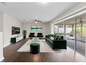 Staged living room showcases dark hardwood flooring and sliding glass doors leading to the outdoor area at 14010 102Nd Ave, Largo, FL 33774