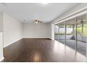 Spacious living room with dark hardwood flooring, ceiling fan, and sliding glass doors to a screened-in porch at 14010 102Nd Ave, Largo, FL 33774