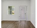 Bright foyer featuring wood-look floors, a white front door with sidelights, and a window at 4344 Jaslo Ave, North Port, FL 34286