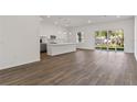 Open-concept living space with wood floors, white walls, and a view into the kitchen and back yard at 4344 Jaslo Ave, North Port, FL 34286