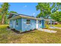 Blue single-story home with landscaped front yard, green grass, and covered carport on a clear day at 3728 19Th E St, Bradenton, FL 34208