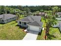 Aerial view of a charming single-story home with tropical landscaping, and an attached two-car garage at 4146 New Milford St, North Port, FL 34288