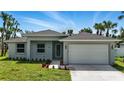 Charming single-story home with a well-manicured lawn, landscaping, and attached two car garage at 4146 New Milford St, North Port, FL 34288