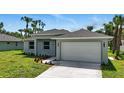 Charming single-story home with a well-manicured lawn, landscaping, and attached two car garage at 4146 New Milford St, North Port, FL 34288