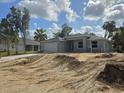 View of a single-story home with a large driveway and landscaping being installed at 4146 New Milford St, North Port, FL 34288